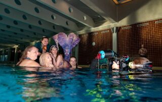 Mermaids am Beckenrand beim Fotoshooting mit Unterwasserkamera